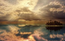 Tranquil island scene with dramatic sunrays piercing through clouds over water.