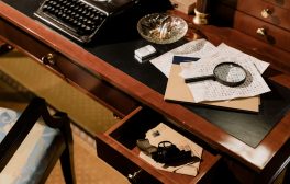 A moody vintage detective's desk with typewriter, magnifying glass, and secret documents.