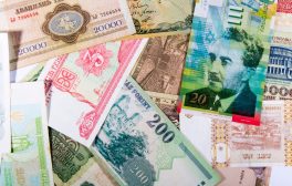 Colorful assortment of international paper currencies from various countries in a flat lay.