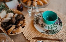 Cozy breakfast setup with various breads and ceramic tableware on a woven placemat.