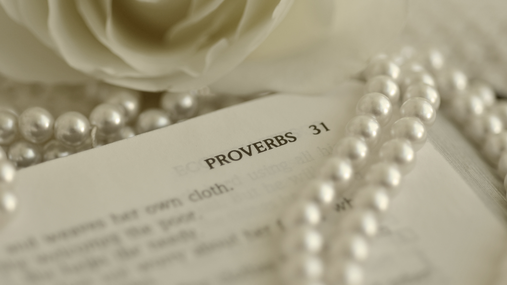 Biblia otwarta na Księdzie Przysłow 31, naszyjnik z pereł obok niej