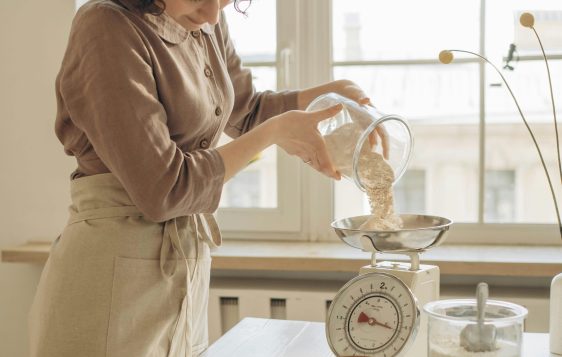 kobieta robiąca ciasto w kuchni, pokazując, czym jest prowadzenie domu